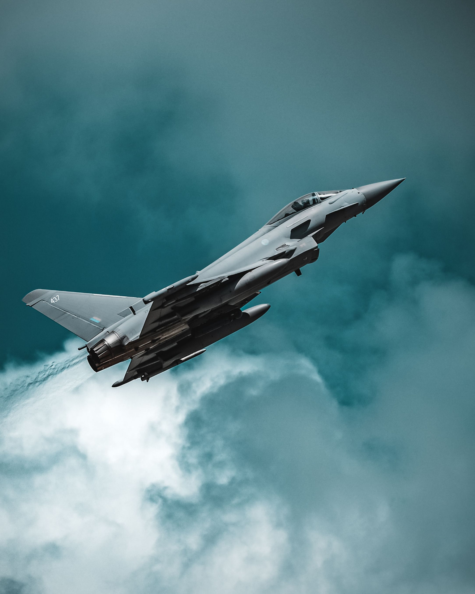 Fighter jet climbing through cloud