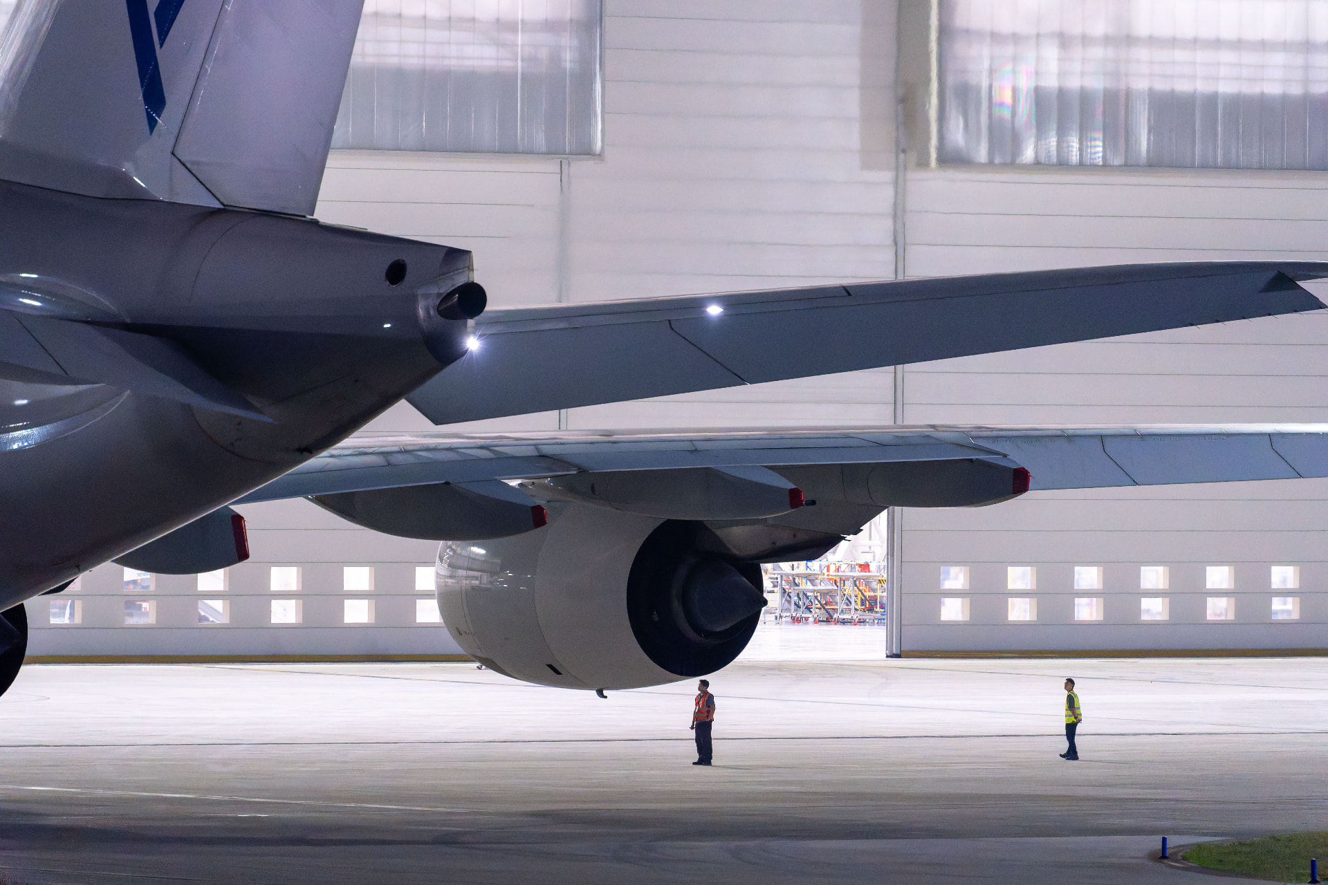 Airliner engine and wing inside a maintenance hangar
