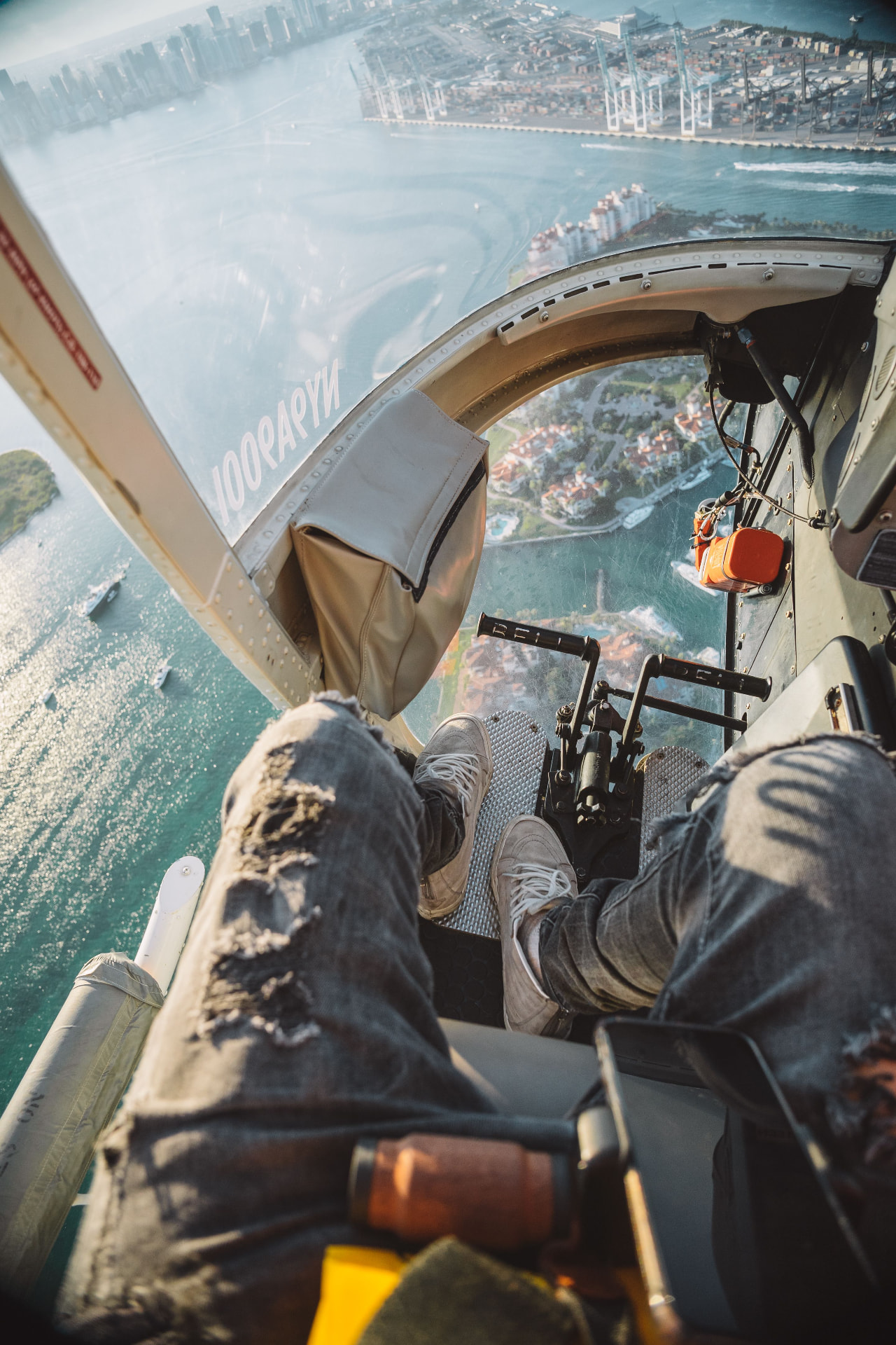 View from the right seat of a helicopter flying above a coastal city