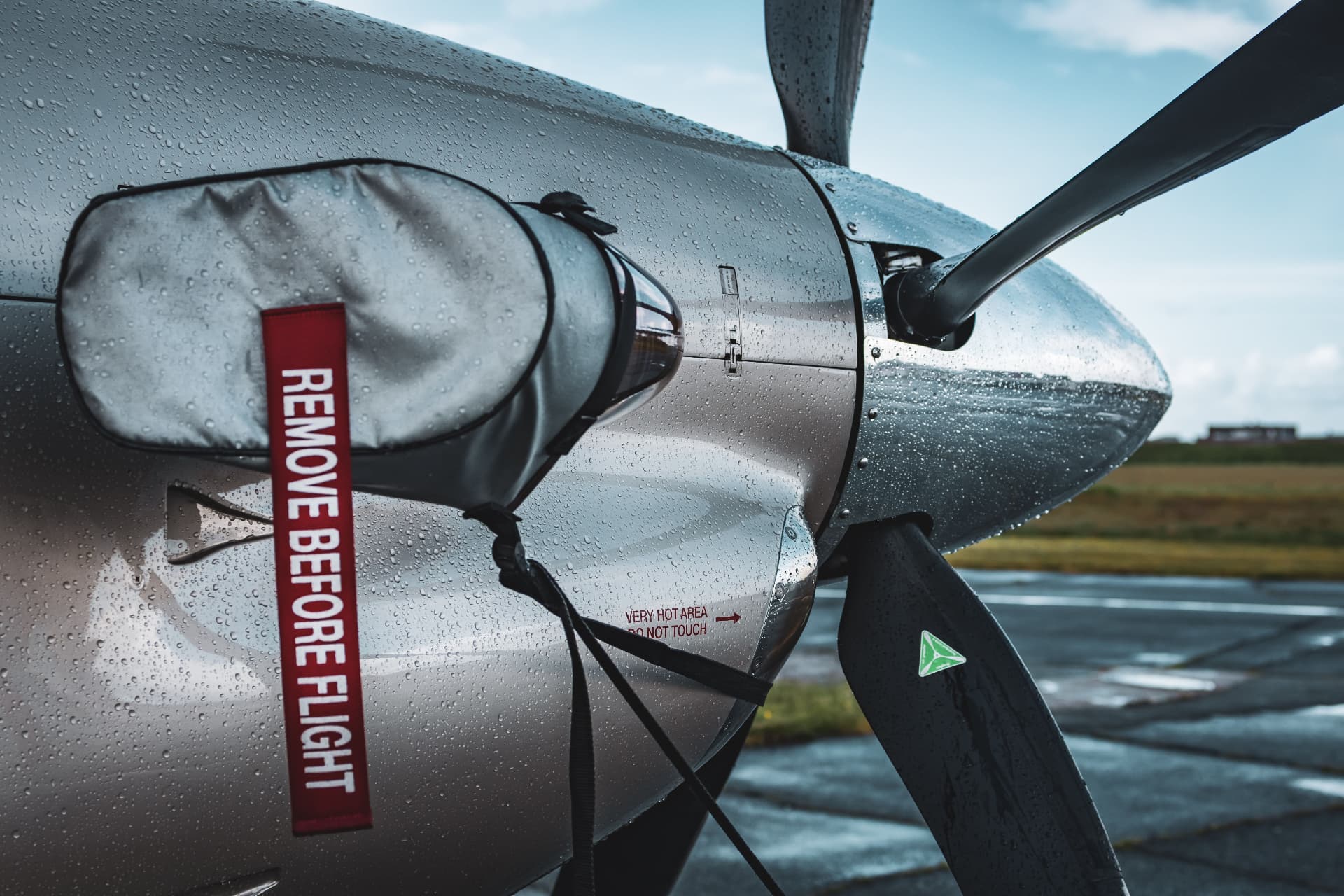 Wet aircraft engine cowling and propeller with a REMOVE BEFORE FLIGHT tag