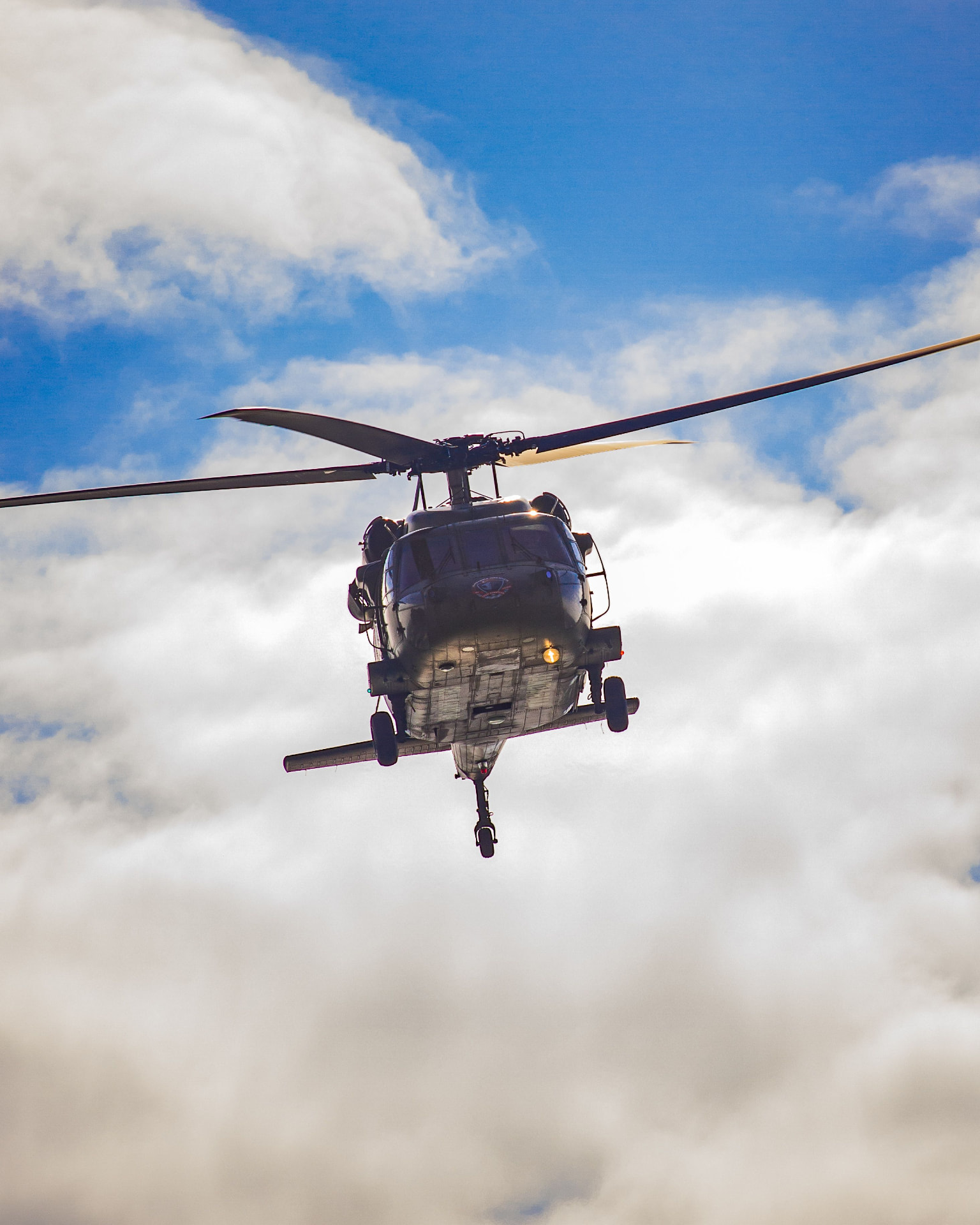 Helicopter flying beneath a bright cloud layer