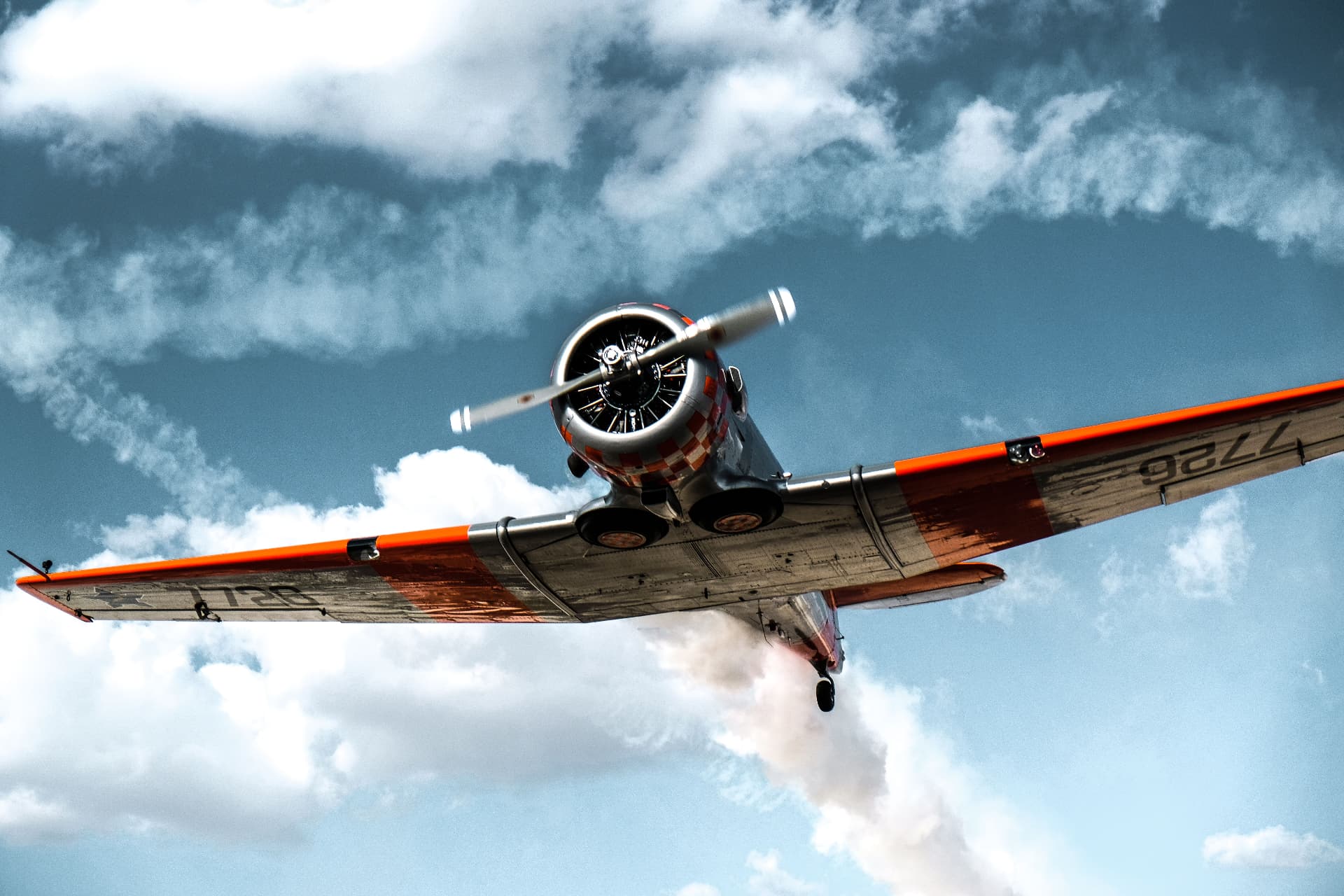Radial-engine training aircraft banking against cloud