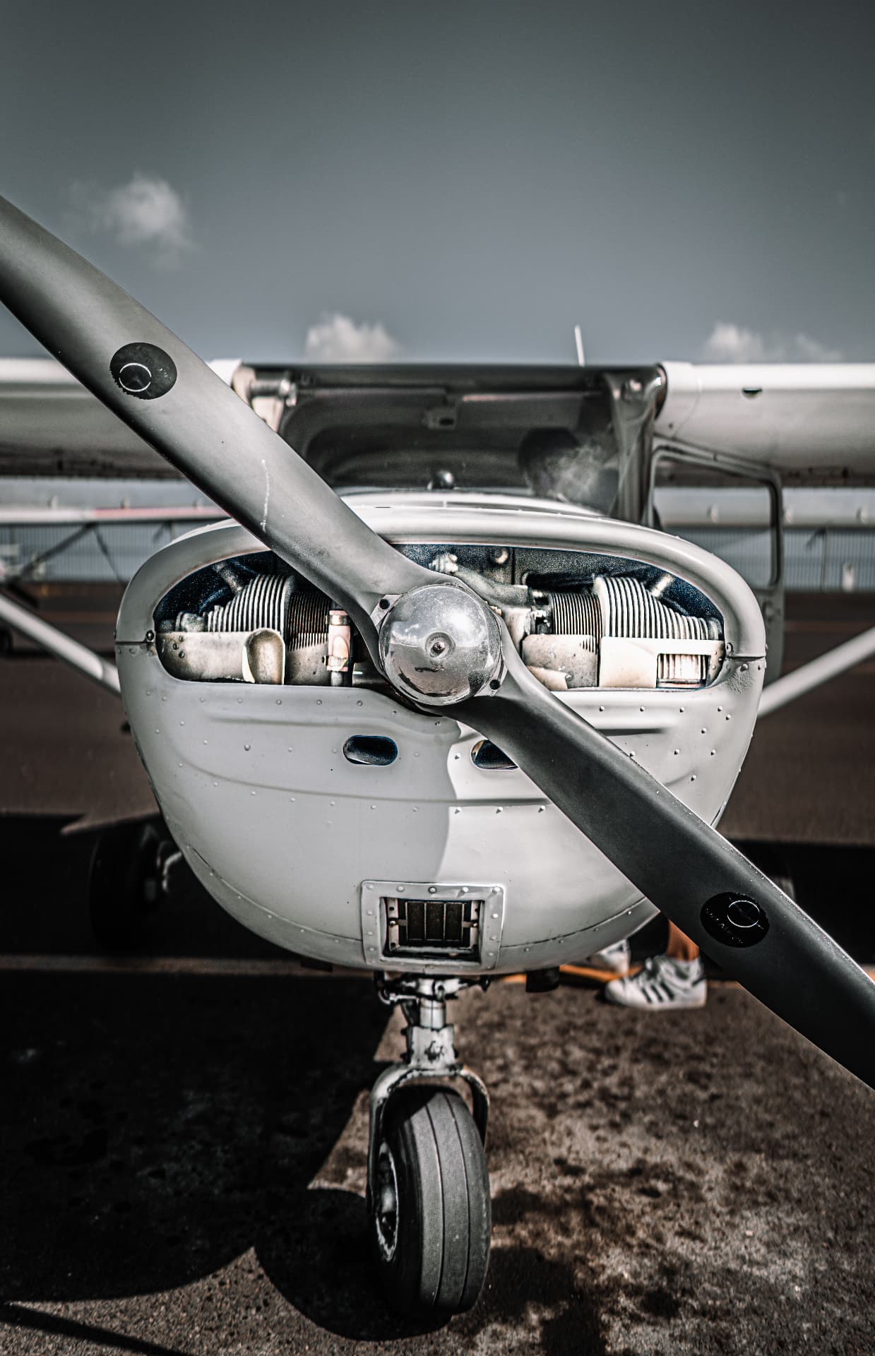 Nose and propeller of a single-engine aircraft with the cowling open for maintenance